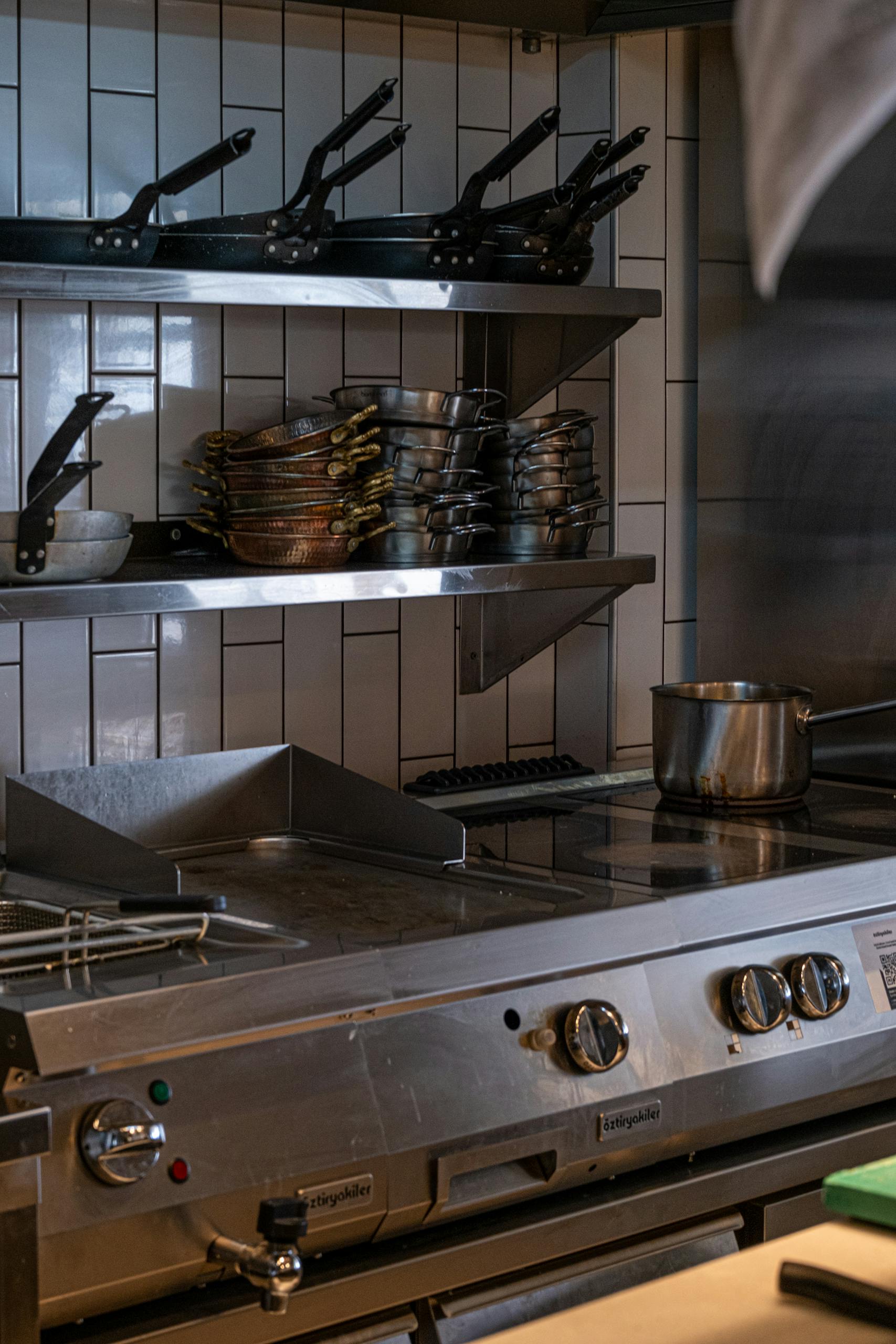 We do pest control in South Florida. Here is Industrial kitchen setup with stainless steel appliances, pots, and pans.